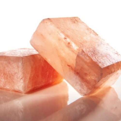 Grouping of pink himalayan salt bars on mirror for cleansing. 